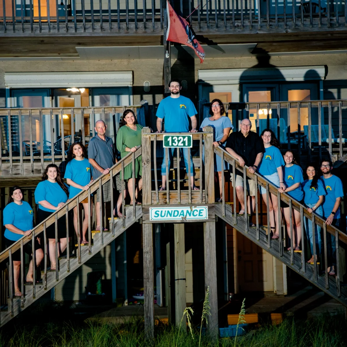 A family photo session at a beach house of a large family posed on the steps of their beach house.