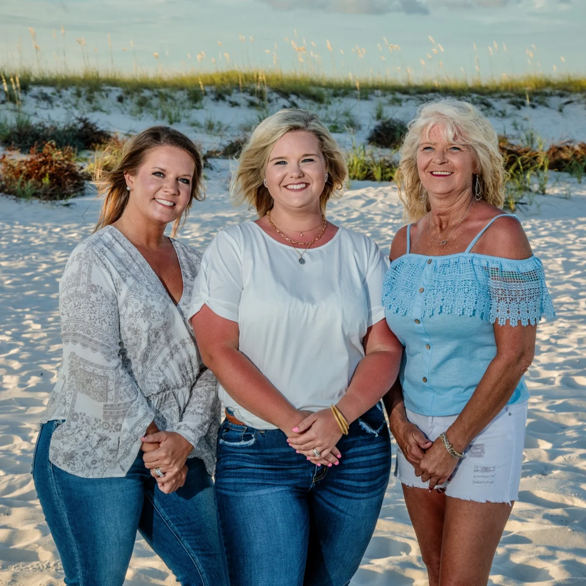 A close-up photo of three women standing on the beach enjoying a good time during their photo session in Fort Morgan, Alabama.