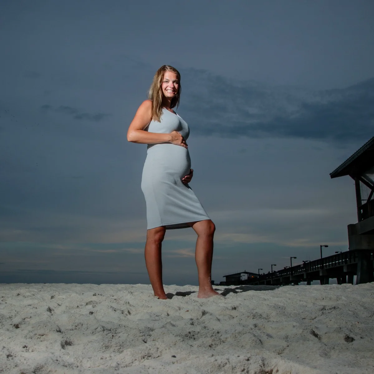 Photo of a pregnant mom standing on the beach during a photo session.