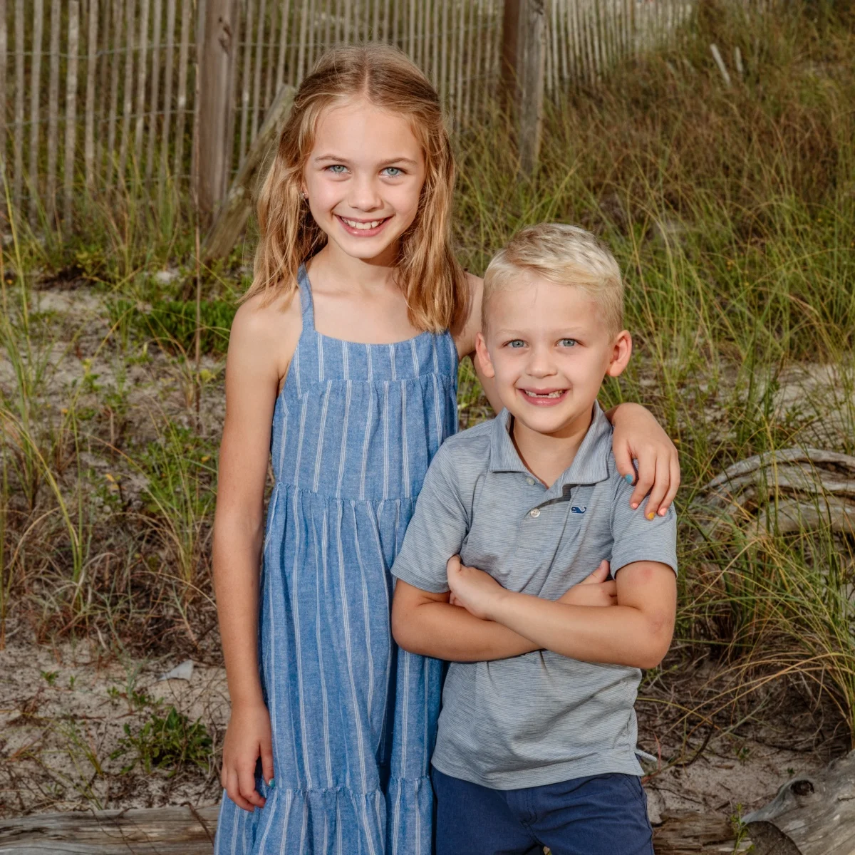 A brother and sister having their photo taken by the beach in Fort Morgan, Alabama.