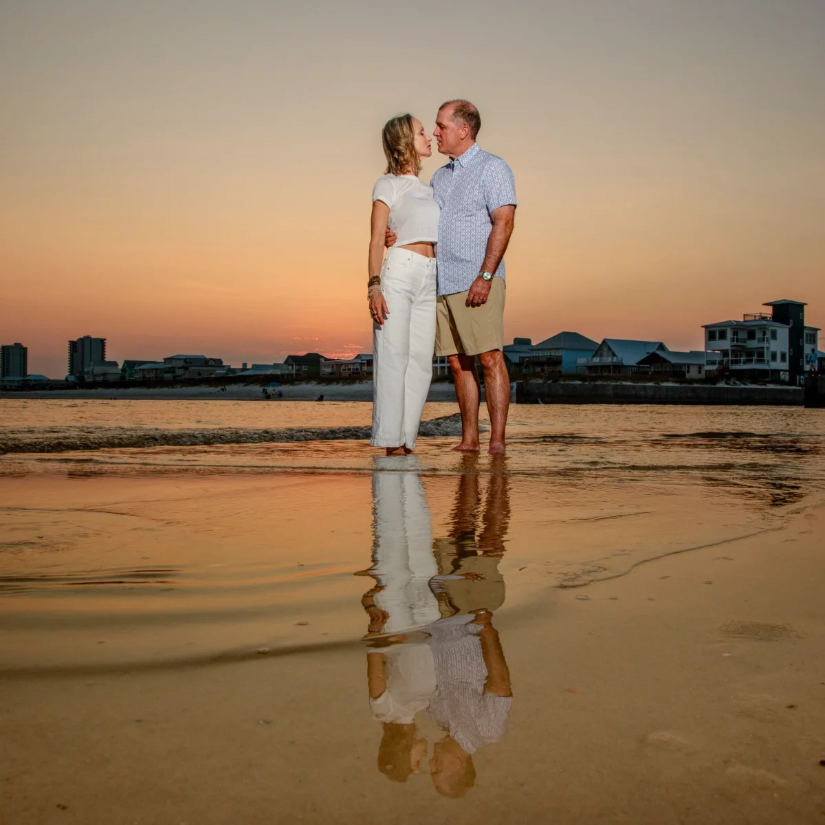 Sunset photo of a couple with a nice reflection in the water in Fort Morgan, Alabama.