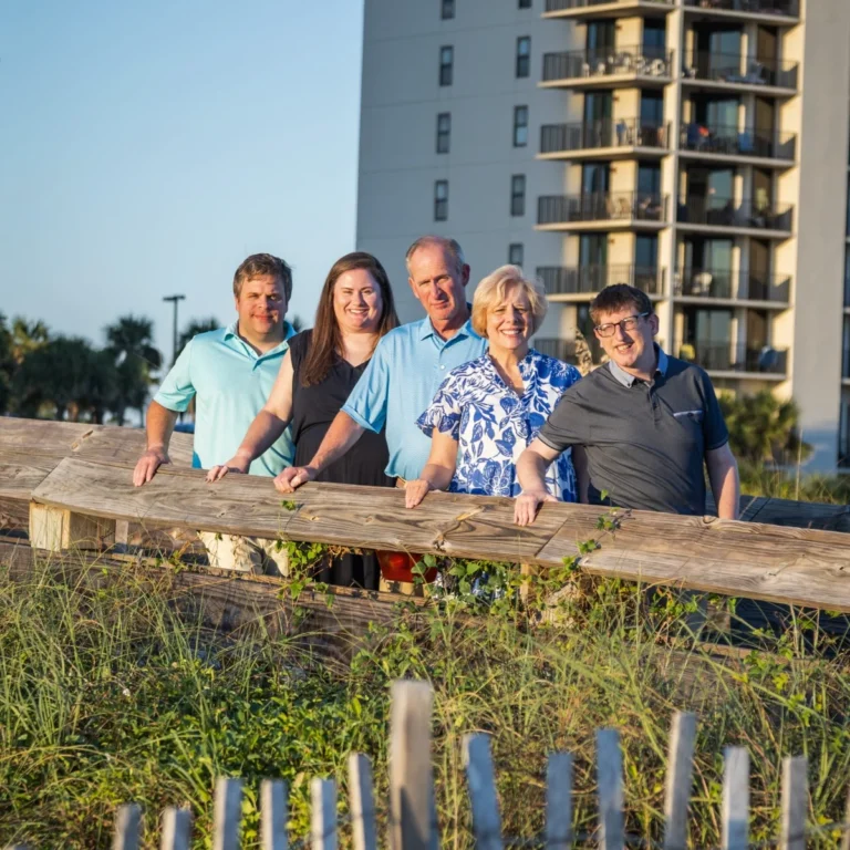 Family of five on the walkway leading out to the beach in Fort Morgan, Alabama.