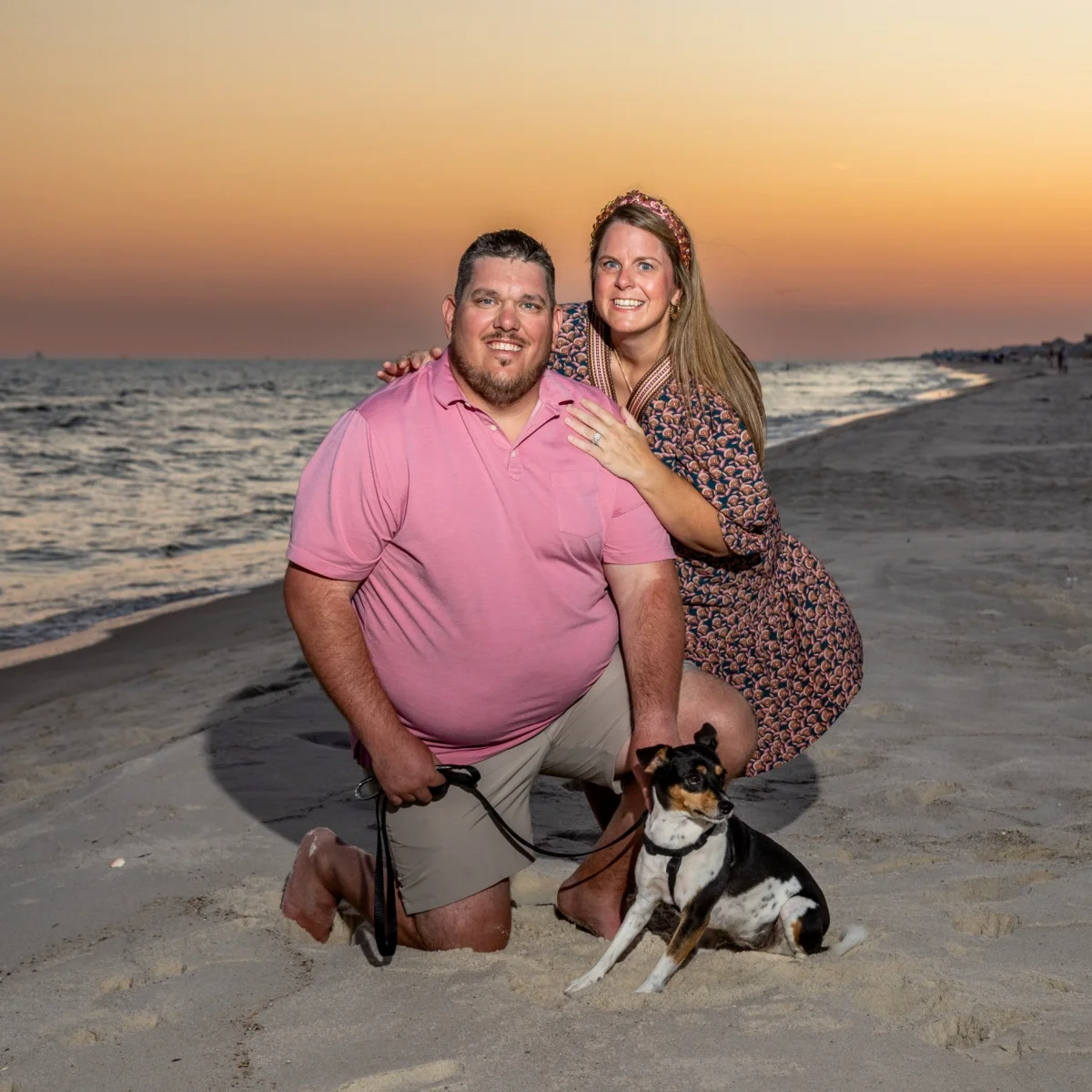 Sunset photo of a couple with a dog in Fort Morgan, Alabama.
